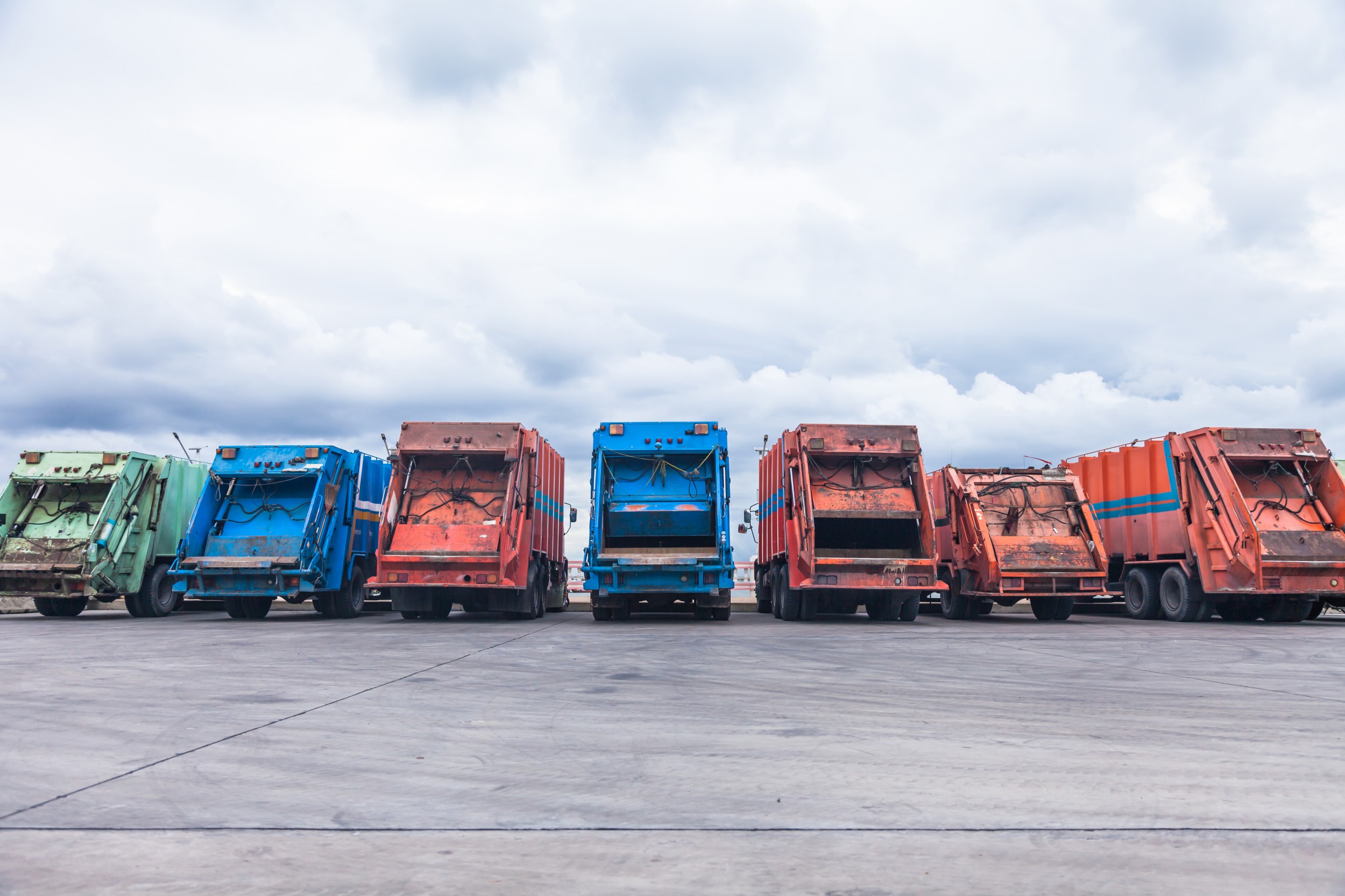 Des camions de transport d’ordures sont en attente sur un parking.